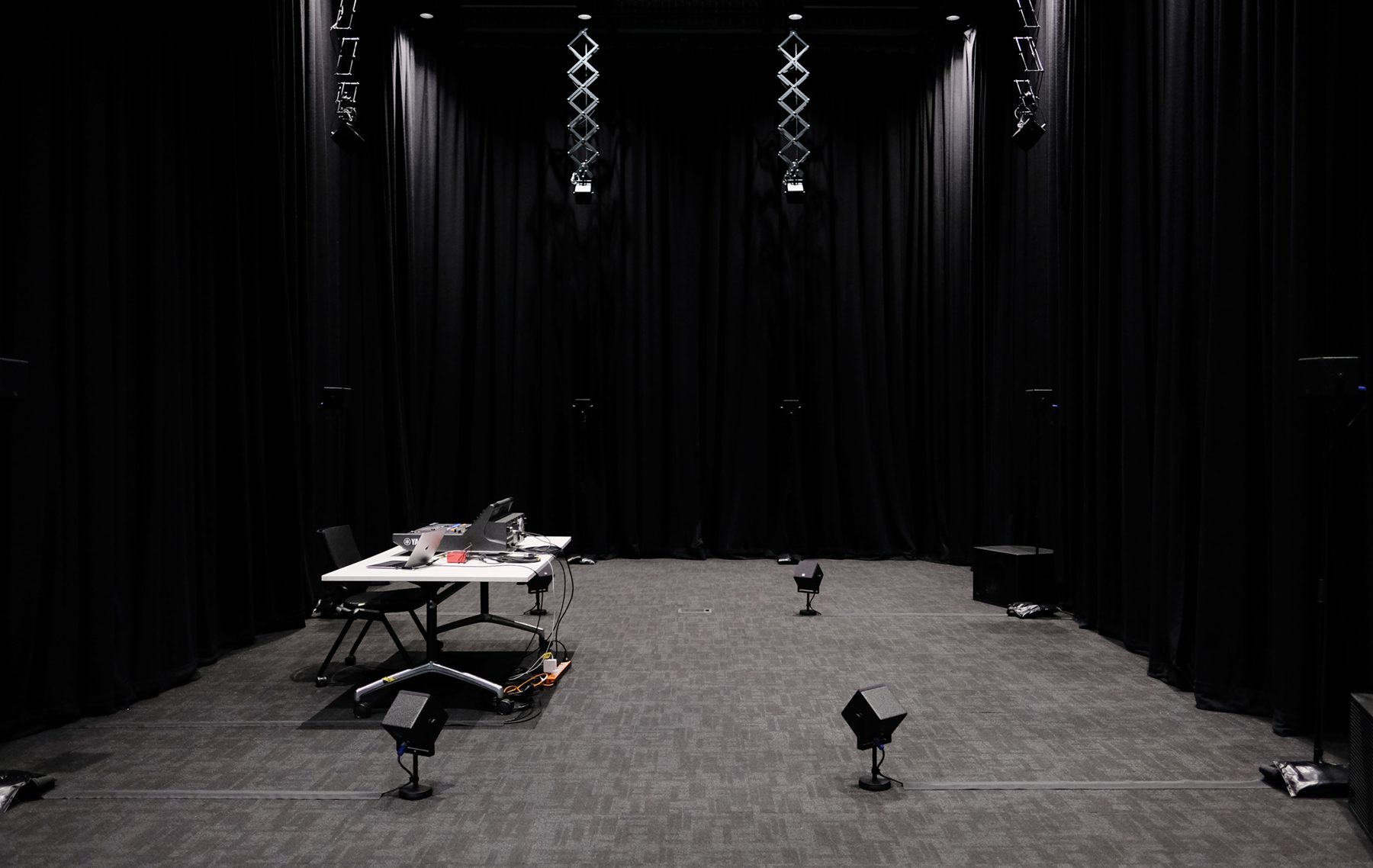 A black curtained room full of speakers